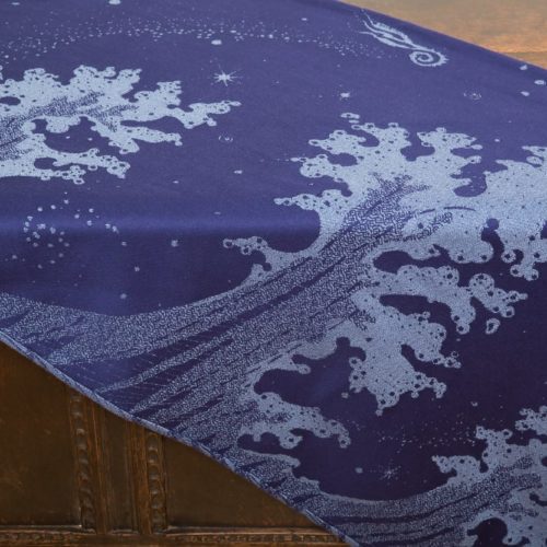 flat shot of a dark blue and grey woven wrap with a crashing wave design