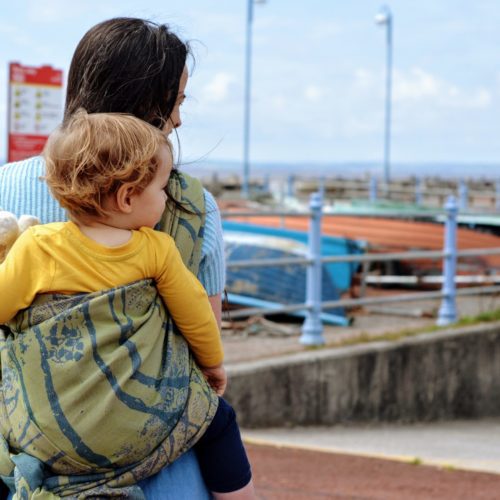 blue and green 100% organic cotton woven wrap tied in a back carry