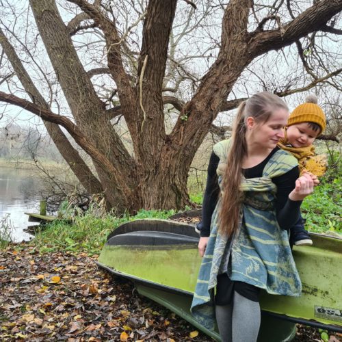 blue and green 100% organic cotton woven wrap in a back carry (ruck tied Tibetan).