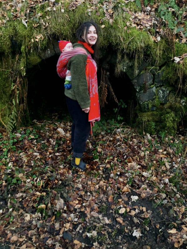 small baby being back carried in a red woven wrap