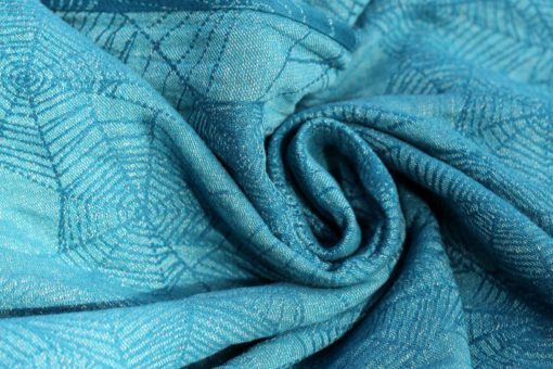 teal and turquoise woven wrap with a cobweb design