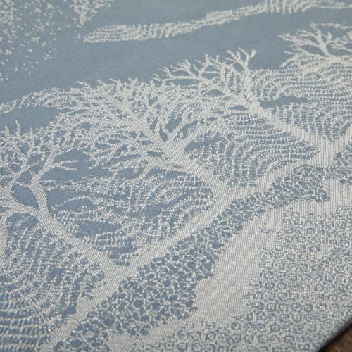 A woven wrap with a pale grey and grey-blue design showing starling murmuration over a wintery treeline