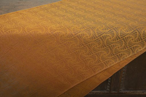 woven wraps feature a geometric design in a shimmery gradient of russet and brown supersoft linens against warm mustard-gold cotton for understated elegance