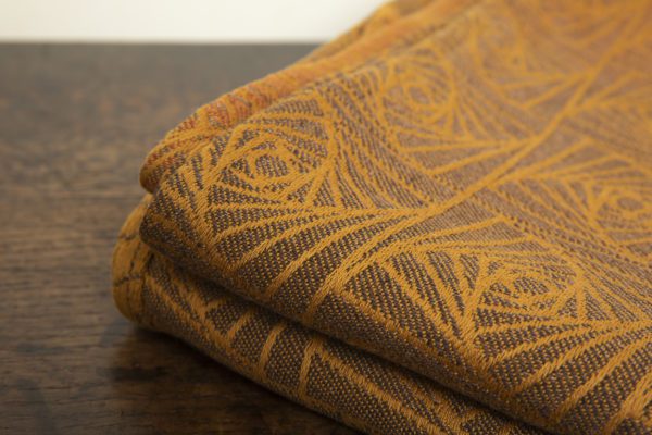 woven wraps feature a geometric design in a shimmery gradient of russet and brown supersoft linens against warm mustard-gold cotton for understated elegance