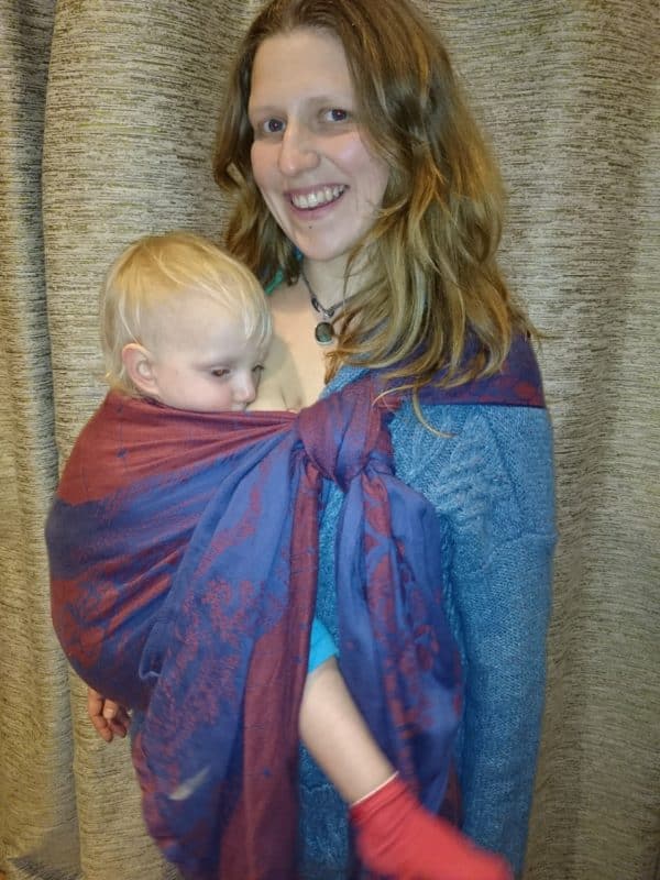 Jen breastfeeding Nina as a toddler in a short woven wrap tied in a traditional hip carry